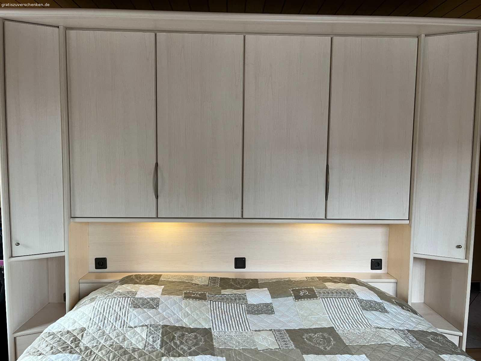 Schlafzimmer Weiß-Kirsche Nachbildung 7 teilig. Ab sofort an Selbstholer abzugeben

H=2,27m
Bestehend aus (s. Zeichnung der ürsprünglichen Aufstellung v. Li. Nach re.):
Schrägeelement 48cm, Schrank 30cm, Eckschrank m. Spiegel und runde Kleiderstange 91x91cm, Schrank 30cm, Überbau m. Beleuchtung 2,71m, 2-ter Echschrank, Schrank 30cm.
Den Fotos können Sie entnehmen, dass sich die Teile im Zusammenbau variieren lassen.
Wahlweise m. Bettkasten OHNE Lattenrost und Matratzen.
Der Rahmen ist und unbeschädigt. Er wurde mit Wassermatratzen  genutzt und wurde nur zur Stabilisierung verstärkt. Evtl. müssen die Eckscharniere ausgetauscht werden. Teile müssen vom Abholer selbst abgebaut u. Aus der 1. Etage transportiert werden.