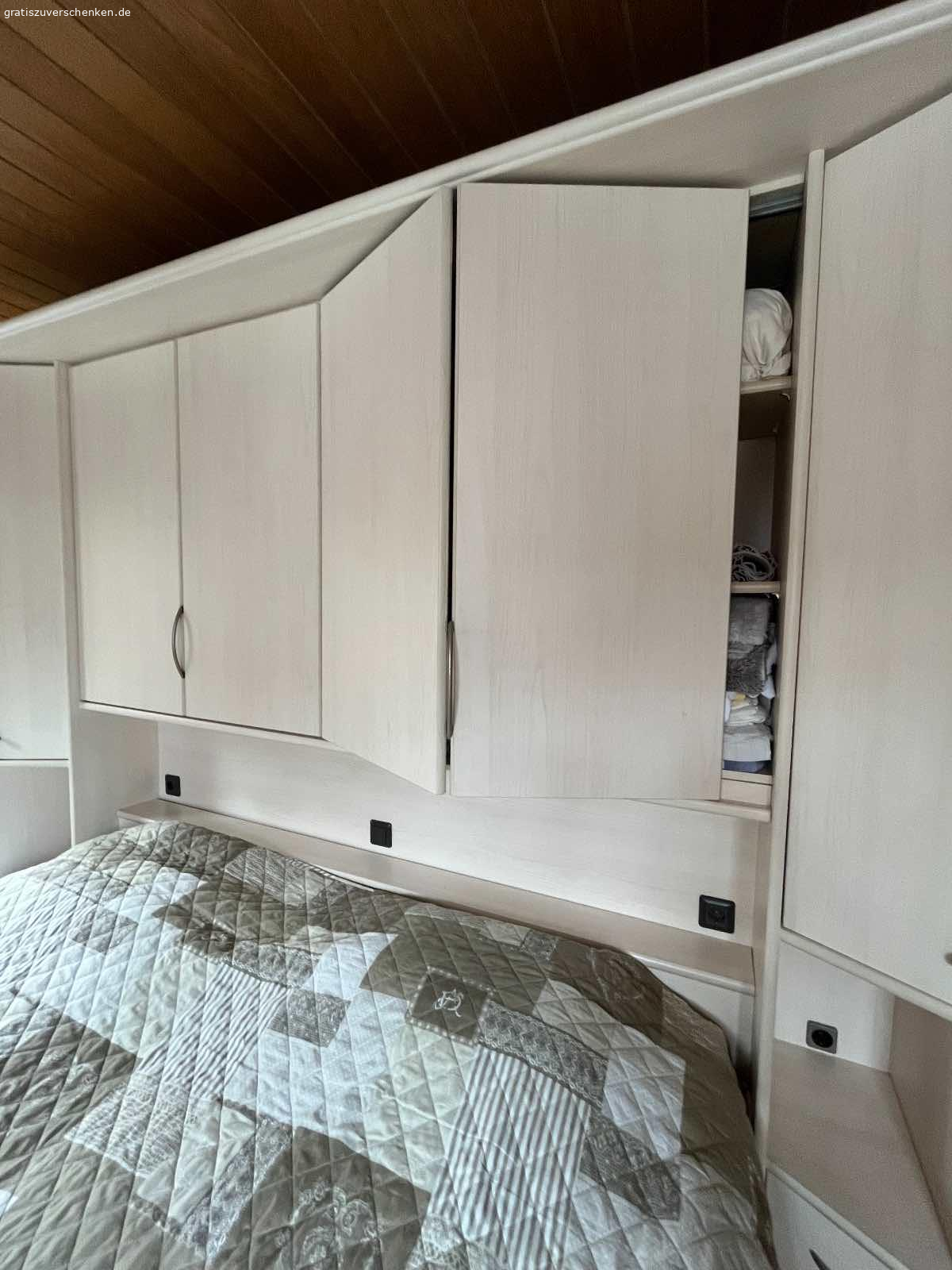 Schlafzimmer Weiß-Kirsche Nachbildung 7 teilig. Ab sofort an Selbstholer abzugeben

H=2,27m
Bestehend aus (s. Zeichnung der ürsprünglichen Aufstellung v. Li. Nach re.):
Schrägeelement 48cm, Schrank 30cm, Eckschrank m. Spiegel und runde Kleiderstange 91x91cm, Schrank 30cm, Überbau m. Beleuchtung 2,71m, 2-ter Echschrank, Schrank 30cm.
Den Fotos können Sie entnehmen, dass sich die Teile im Zusammenbau variieren lassen.
Wahlweise m. Bettkasten OHNE Lattenrost und Matratzen.
Der Rahmen ist und unbeschädigt. Er wurde mit Wassermatratzen  genutzt und wurde nur zur Stabilisierung verstärkt. Evtl. müssen die Eckscharniere ausgetauscht werden. Teile müssen vom Abholer selbst abgebaut u. Aus der 1. Etage transportiert werden.