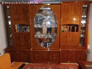 Wohnzimmer Schrank im italienischen Stil. Wohnzimmer Schrank im italienischen Stil. Sehr gut erhalten. Keine Kratzer, keine Fehler Maße: 3m breit 2,21 hoch, wenn der ovale Kranz aufgesetzt wird (derzeit nicht auf dem Bild) Farbe ist rotbraun, Furnier, mit Einlagen. 6 Korpus-Teilen zzgl. Türen, Kranz, Glas- und Holzeinlage-Böden. Geschirr, Kristall-Gläser etc. können wir gerne zum Teil mit verschenken